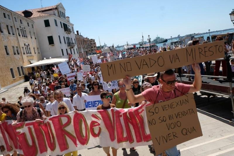 A resident holds a placard " I don't want to go, i'm staying" during a protest in Venice, Italy, July 2, 2017. Picture taken on July 2, 2017REUTERS/Manuel Silvestri